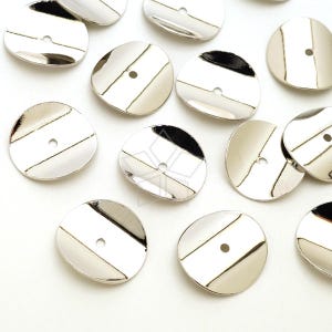 May include: A group of 15 silver-toned metal round embellishments with a hole in the center. The embellishments are slightly domed and have a shiny finish.