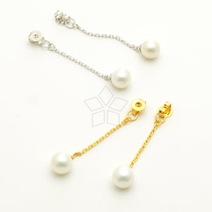 Könnte beinhalten: Zwei Paar Perlenohrringe mit einer baumelnden Kette. Ein Paar hat eine goldene Kette und das andere eine silberne Kette.