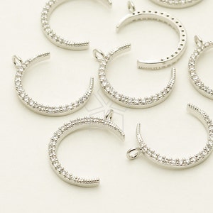 May include: Silver crescent moon charms with clear crystal accents. Each charm has a loop for attaching to jewelry.
