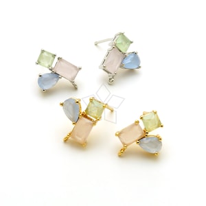 以下が含まれることがあります： 幾何学的なデザインのイヤリングが3ペア。各イヤリングはピンク、グリーン、ブルーのストーンを組み合わせています。