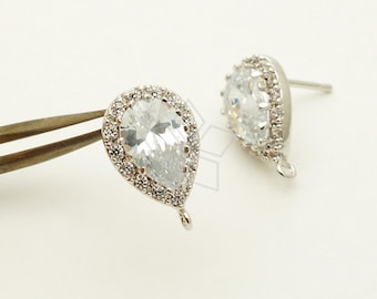 May include: A pair of silver teardrop-shaped earring findings with clear cubic zirconia stones. The stones are set in a halo of smaller stones. The findings have a loop at the bottom for attaching a dangle.