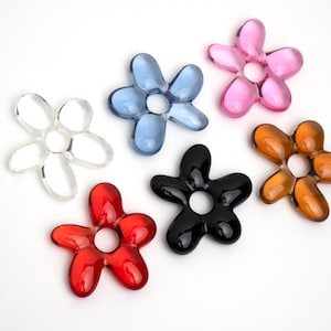Può includere: Sei ciondoli a forma di fiore colorati in vetro. I ciondoli sono di vari colori, tra cui trasparente, blu, rosa, rosso, nero e marrone.