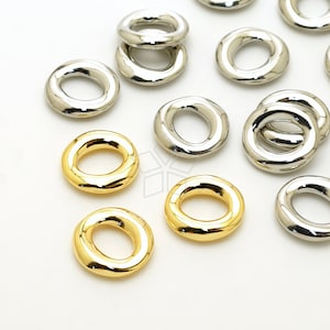 May include: A collection of gold and silver metal rings. The rings are all different sizes and shapes, but they all have a smooth, polished finish.