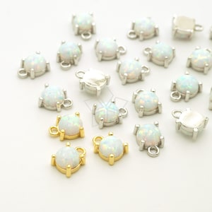 Puede incluir: Una colección de dijes de piedra de ópalo blanco con engastes en tono plateado y dorado. Los dijes tienen un bucle para sujetarlos a joyas.