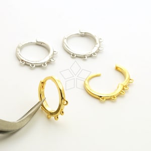 May include: Three pairs of hoop earrings with jump rings. Two pairs are silver and one pair is gold.