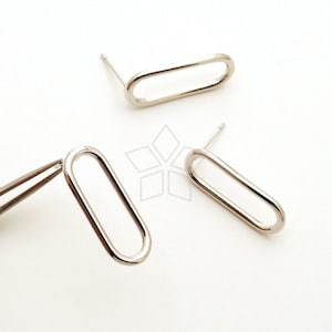 May include: A pair of silver oval-shaped stud earrings. The earrings are simple and modern in design.