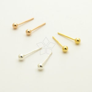May include: Three pairs of stud earrings with small round balls. The earrings are in gold, rose gold, and silver.