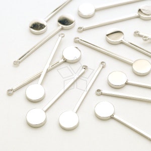May include: Silver metal stick with a round, flat, silver metal circle at the end. There are multiple sticks in the image, all with the same design.