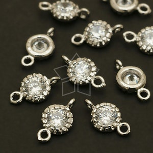May include: Silver-toned metal connector charms with clear rhinestone accents. Each charm features a round rhinestone surrounded by a smaller rhinestone halo. The charms have two loops for attaching to jewelry.