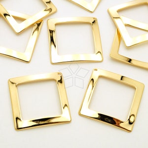 Puede incluir: Un conjunto de diez marcos cuadrados de metal de color dorado con un acabado liso y brillante. Cada marco tiene un pequeño agujero en la parte superior para colgar o sujetar.