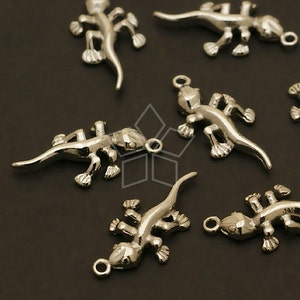 May include: A set of silver-toned lizard charms. The charms are detailed and have a realistic look. They are perfect for adding a touch of whimsy to jewelry or crafts.