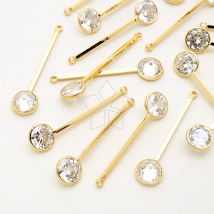 Könnte beinhalten: Eine Gruppe von goldfarbenen Haarklammern mit klaren, runden Strasssteinen. Die Klammern liegen auf einer weißen Oberfläche.