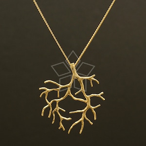 Può includere: Una collana d'oro con un delicato ciondolo a forma di ramo. Il ciondolo è realizzato in un unico pezzo di metallo e ha un aspetto naturale e organico.