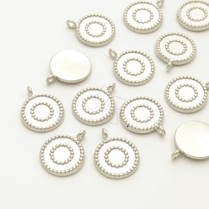 May include: Silver-toned metal charms with a circle design. Each charm has a loop for attaching to jewelry or other crafts.