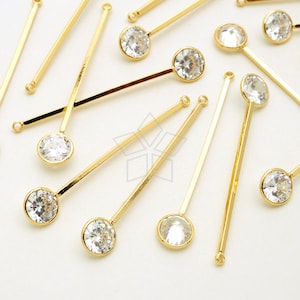 Puede incluir: Una colección de horquillas de metal dorado con brillantes redondos transparentes en el extremo.