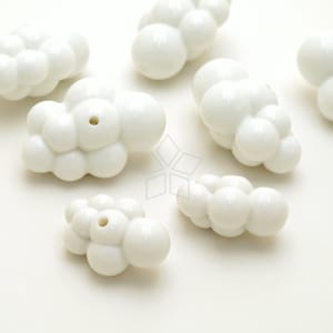 May include: A set of seven white ceramic beads, each shaped like a cluster of small, round bubbles. The beads have a smooth, glossy finish and are perfect for adding a touch of whimsy to jewelry or other crafts.