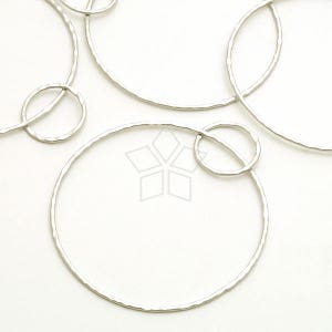 May include: A set of five silver-toned metal hoops of varying sizes. The hoops are all hammered and have a textured finish.