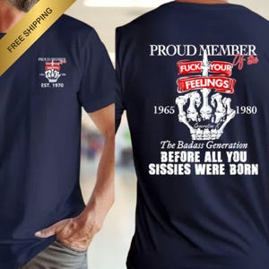 May include: Navy blue t-shirt with a graphic on the front and back. The front graphic says "PROUD MEMBER" with a skeleton hand and the text "EST. 1970". The back graphic says "PROUD MEMBER" with the text "FUCK YOUR FEELINGS" and "The Badass Generation".