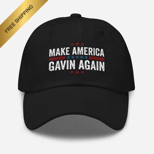 Puede incluir: Gorra de béisbol negra con el texto "MAKE AMERICA GAVIN AGAIN" en blanco, rojo y azul. El texto está dispuesto en dos líneas con estrellas arriba y abajo. Una pancarta dorada con las palabras "FREE SHIPPING" está en la esquina superior izquierda.
