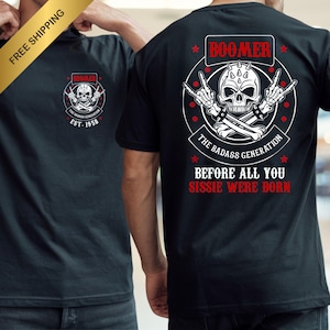 Op de afbeelding: Zwart T-shirt met een schedelafbeelding en de tekst "BOOMER" erboven en "THE BADASS GENERATION" eronder. Het shirt heeft ook de tekst "EST. 1958" en "BEFORE ALL YOU SISSIE WERE BORN".