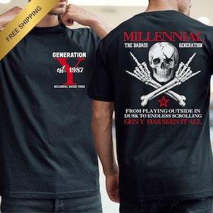 May include: Black t-shirts with white and red graphics. One shirt says "GENERATION Y est. 1987 MILLENNIAL RAISED TOUGH". The other features a skull with crossed bones and the text "MILLENNIAL THE BADASS GENERATION FROM PLAYING OUTSIDE IN DUSK TO ENDLESS SCROLLING GEN Y HAS SEEN IT ALL".