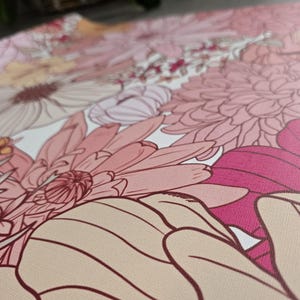 May include: A close-up of a floral print fabric with pink, white, and red flowers. The fabric has a textured surface and a delicate floral pattern.