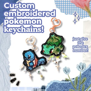 May include: Two custom embroidered Pokemon keychains with heart-shaped rose gold clasps. One features a blue character, the other a green character, both with black borders and dangling beads. Text reads: Custom embroidered pokemon keychains! just give the pokedex number!