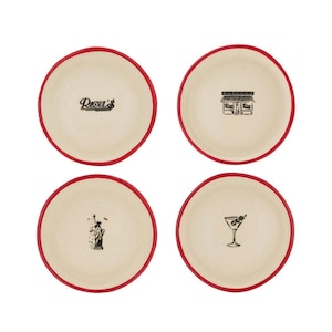 May include: A set of four round ceramic plates with a cream-colored center and a bold red rim. Each plate features a unique black ink illustration: the text Raoul's, a storefront facade, the Statue of Liberty, and a martini glass with olives.