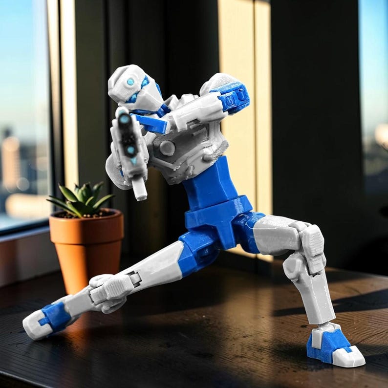 Pode incluir: Uma figura de a&ccedil;&atilde;o branca, azul e cinza em uma pose din&acirc;mica, segurando uma pistola futurista. A figura &eacute; articulada, com juntas vis&iacute;veis e um design detalhado. Est&aacute; posicionada em uma superf&iacute;cie escura perto de uma planta em vaso.
