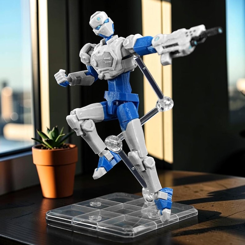 Pode incluir: Figura de a&ccedil;&atilde;o articulada em pose din&acirc;mica, com esquema de cores branco e azul. A figura segura uma arma branca e est&aacute; montada numa base transparente. Um pequeno vaso de plantas &eacute; vis&iacute;vel.