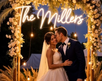 Puede incluir: Escena de boda romántica con una pareja bajo un arco floral adornado con luces de cadena. Un letrero de neón dice "The Millers". La novia lleva un vestido blanco y velo, y el novio un traje azul marino. La escena tiene lugar al aire libre al anochecer.