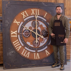 May include: Large, industrial-style wall clock with Roman numerals in a copper color. The clock face features intricate gear details and a dark metal frame. The clock hands are gold-colored. The clock is approximately 6 feet tall.