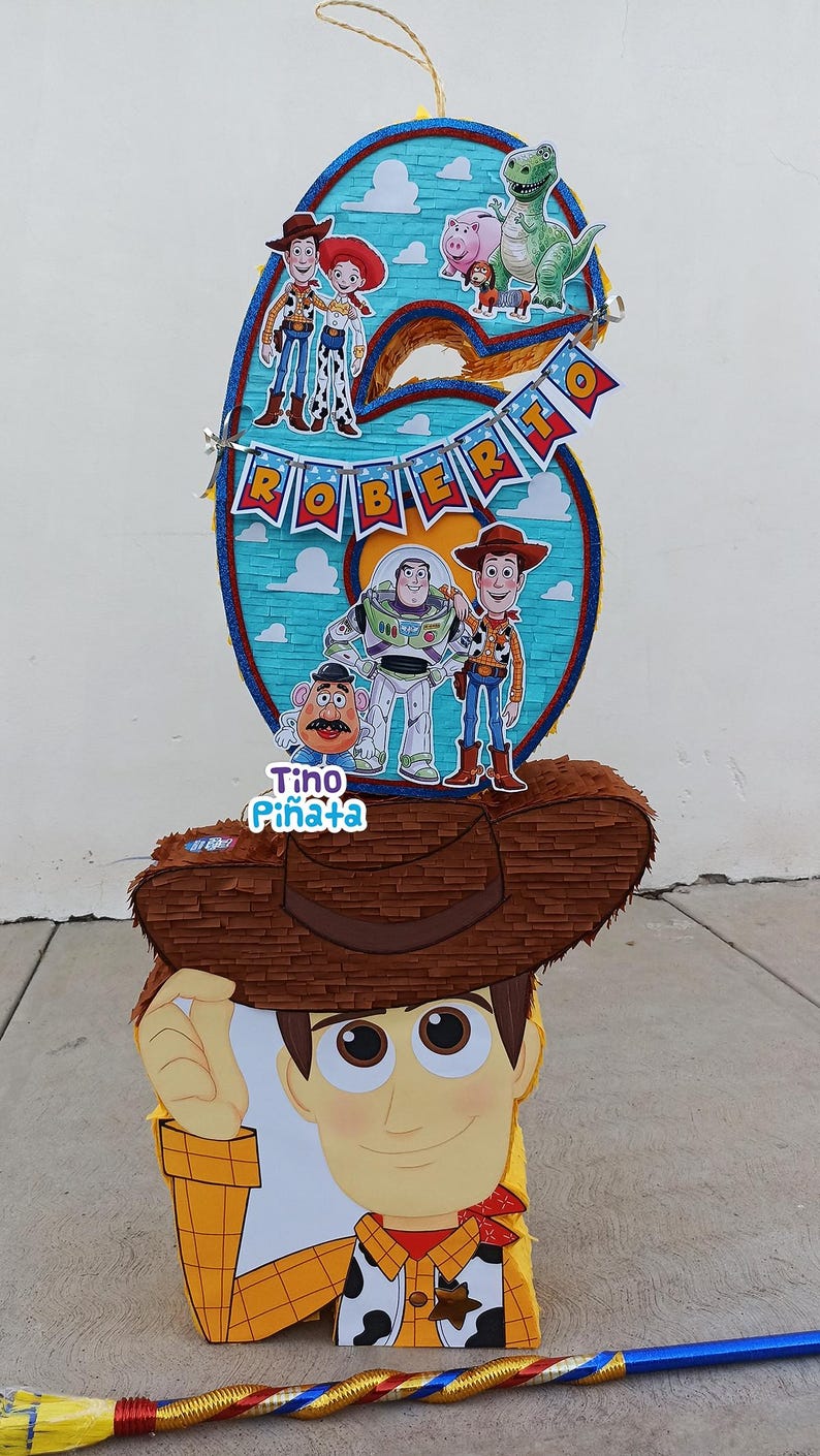 May include: A white ceramic mug with a black handle and the text "But First, Coffee" in a bold, black font. The mug is set against a blurred background, suggesting a cozy setting.