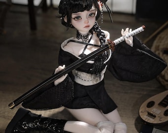May include: A doll with black hair and a black outfit, holding a katana. The doll is wearing black boots and a choker. A black mask is on the doll's head. The doll is kneeling on a wooden surface.