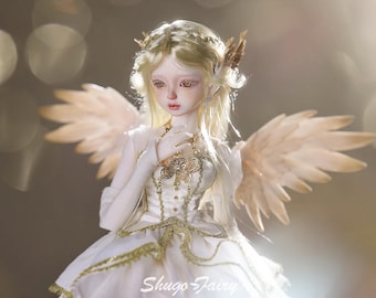 May include: A detailed image of a doll with a serene expression, adorned with feathered wings and a white dress with gold accents. The doll has long, blonde hair and is wearing a delicate necklace. The image has a soft, ethereal quality, with the text "Shugo Fairy" at the bottom.