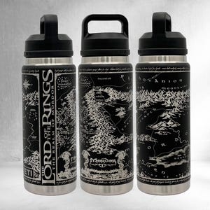 May include: Three stainless steel water bottles with black lids. Each bottle features a black and white map design with text from "The Lord of the Rings: The Realm of Mordor". The bottles have a handle for easy carrying.