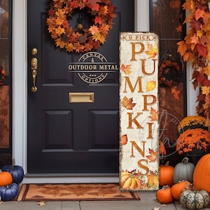 May include: A tall, rectangular vertical sign with a distressed white finish featuring the text U PICK PUMPKINS in large brown letters. The sign is decorated with illustrations of orange and yellow autumn leaves and orange pumpkins at the base.