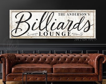 May include: A white wooden sign with black text that reads "The Anderson's Billiards Lounge". The sign has a distressed, vintage look and is perfect for a game room or bar.