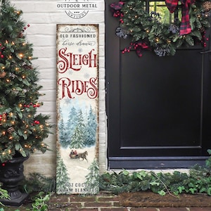 May include: A vintage-style sign with a snowy forest scene and a horse-drawn sleigh. The sign reads "Old Fashioned Horse Drawn Sleigh Rides" with the words "Hot Cocoa Warm Blankets" at the bottom.