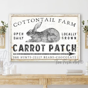 May include: A black and white sign with the text "Cottontail Farm" and a rabbit illustration. The sign also says "Open Daily", "Locally Grown", and "Carrot Patch". The text "Egg Hunts, Jelly Beans, Chocolate" is below the main text. The sign is hanging on a white wall above a wooden console table with two wire baskets.