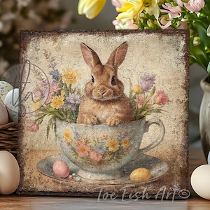May include: A brown bunny rabbit sits in a floral teacup with a saucer. The teacup and saucer are decorated with flowers and the bunny is surrounded by flowers. The background is a vintage-style, faded brown.