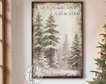 May include: A rectangular wall art print featuring a snowy forest scene with evergreen trees and the text "LET HEAVEN AND NATURE SING" in a dark serif font. The artwork has a distressed, weathered border and a muted, vintage color palette.