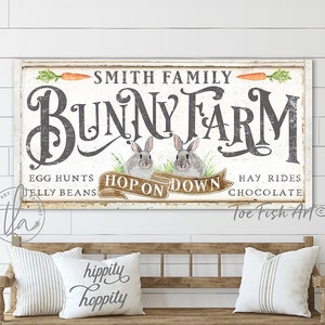 May include: A rectangular wooden sign with the text "SMITH FAMILY BUNNY FARM" in a distressed font. The sign features illustrations of carrots and rabbits, with the phrases "EGG HUNTS," "JELLY BEANS," "HAY RIDES," and "CHOCOLATE." Below, a bench with pillows.