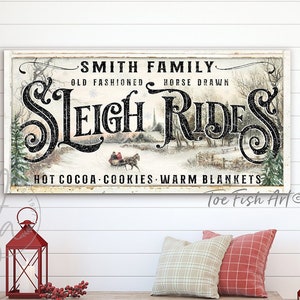 May include: A vintage-style sign with the text "Smith Family Old Fashioned Horse Drawn Sleigh Rides Hot Cocoa Cookies Warm Blankets" in black lettering on a white background. The sign features a winter scene with a horse-drawn sleigh and trees.