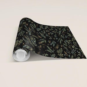 May include: A roll of black wallpaper with a botanical pattern. The design features green and gold-colored leaves and small floral accents. The wallpaper is unrolled, revealing the pattern.