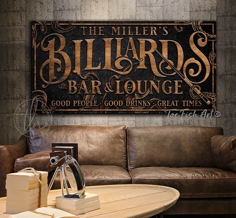 May include: A vintage-style sign with a dark background and gold lettering that reads "The Miller's Billiards Bar & Lounge. Good People. Good Drinks. Great Times." The sign has a decorative border and a sword design.