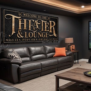 May include: A black and gold sign with the text "Welcome to the Theater & Lounge" and "Movies, Popcorn, Drinks, Games" with the text "Toe Fish Art" at the bottom.