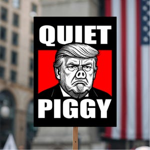 May include: A protest sign with the words "QUIET PIGGY" in white block letters. The sign features a caricature of a man with a pig nose and a red background. The background includes an American flag.