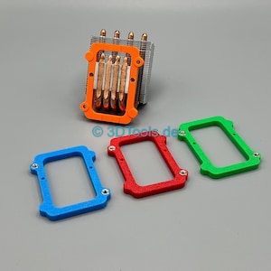 Peut inclure: Un refroidisseur de processeur d'ordinateur orange, argenté et cuivré, avec trois cadres colorés : bleu, rouge et vert. Les cadres sont rectangulaires avec des coins arrondis et de petits trous de vis. Le refroidisseur a des caloducs en cuivre.