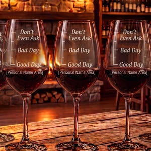 May include: A set of four clear glass wine glasses, each featuring a vertical measurement scale etched on the side with the text Don't Even Ask, Bad Day, Good Day, and Personal Name Area. The glasses have long stems and round bases.